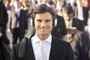 Male commuter in crowd wearing headphones