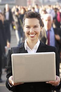 Female commuter in crowd using laptop