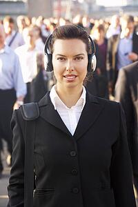 Female commuter in crowd wearing headphones