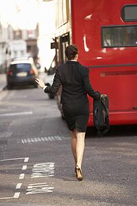 Businesswoman running for bus 