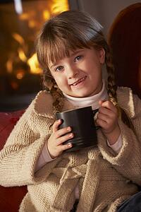 Young Girl Relaxing With Hot Drink By Cosy Log Fire