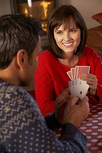 Couple Playing Cards By Cosy Log Fire