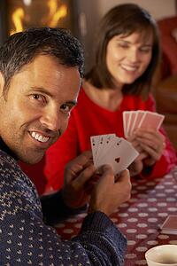 Couple Playing Cards By Cosy Log Fire