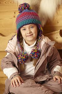 Young Girl Sitting On Wooden Seat Wearing Warm Outdoor Clothes