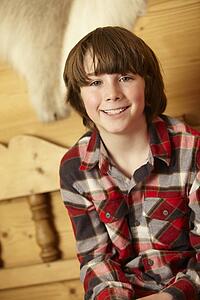 Young Boy Sitting On Wooden Seat