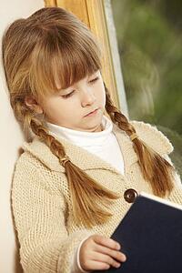 Young Girl Sitting On Wooden Seat Reading Book
