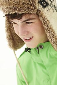 Portrait Of Teenage Boy In Snow Wearing Fur Hat