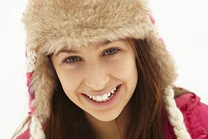 Portrait Of Teenage Girl In Snow Wearing Fur Hat