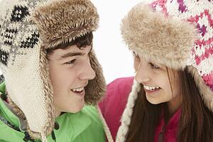 Teenage Couple In Snow Wearing Fur Hats