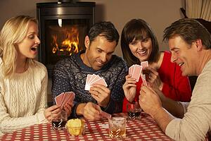 Group Of Middle Aged Couples Playing Cards Together
