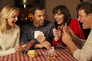 Group Of Middle Aged Couples Playing Cards Together