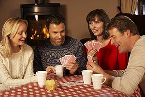 Group Of Middle Aged Couples Playing Cards Together