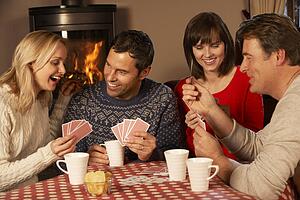 Group Of Middle Aged Couples Playing Cards Together