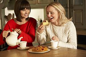 Two Middle Aged Women Enjoying Tea And Cake Together
