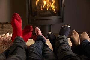 Close Up Of Familys Feet Relaxing By Cosy Log Fire With Marshmallows
