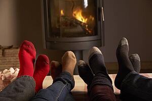 Close Up Of Familys Feet Relaxing By Cosy Log Fire With Marshmallows