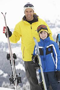 Father And Son On Ski Holiday In Mountains