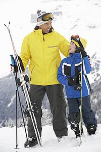 Father And Son On Ski Holiday In Mountains