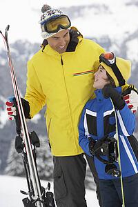 Father And Son On Ski Holiday In Mountains