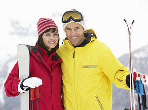 Middle Aged Couple On Ski Holiday In Mountains