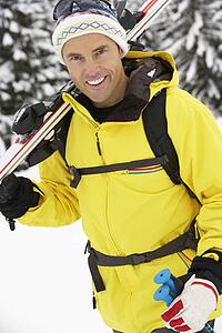 Middle Aged Man On Ski Holiday In Mountains