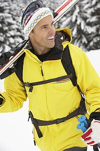 Middle Aged Man On Ski Holiday In Mountains