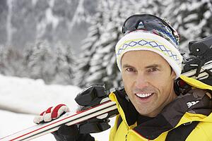 Middle Aged Man On Ski Holiday In Mountains