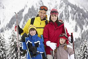 Family On Ski Holiday In Mountains