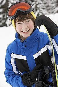 Young Boy With Snowboard On Ski Holiday In Mountains