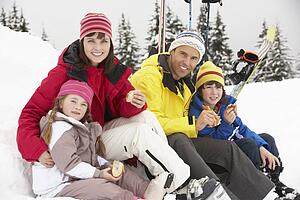 Family Eating Sandwich On Ski Holiday In Mountains