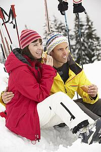Middle Aged Couple Eating Sandwich On Ski Holiday In Mountains