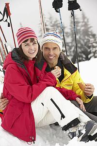 Middle Aged Couple Eating Sandwich On Ski Holiday In Mountains