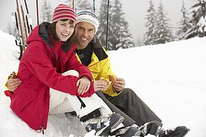 Middle Aged Couple Eating Sandwich On Ski Holiday In Mountains