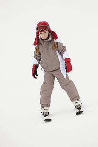 Young Girl Skiing Down Slope On Holiday In Mountains