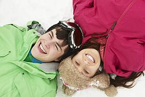 Overhead View Of Two Teenagers On Ski Holiday In Mountains