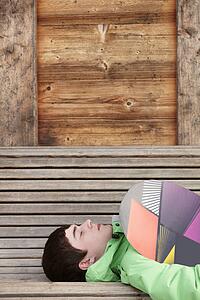 Teenage Boy With Snowboard On Ski Holiday Lying On Wooden Bench