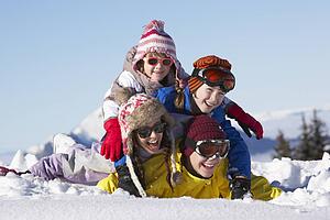 Group Of Children Having Fun On Ski Holiday In Mountains