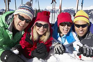 Group Of Middle Aged Couples On Ski Holiday In Mountains