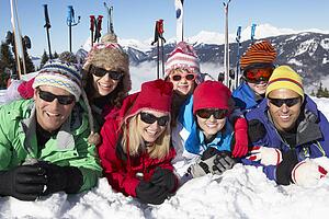 Two Family Having Fun On Ski Holiday In Mountains