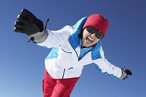Woman Having Fun On Ski Holiday In Mountains