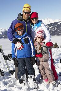 Family On Ski Holiday In Mountains
