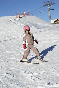 Young Girl Skiing Down Slope Whilst On Holiday In Mountains