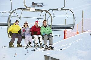 Teenage Family Getting Off chair Lift On Ski Holiday In Mountains
