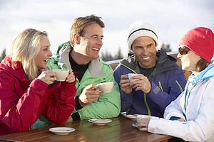 Group Of Friends Enjoying Hot Drink In CafÃ© At Ski Resort
