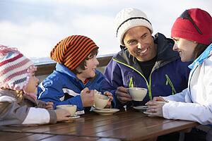 Family Enjoying Hot Drink In CafÃ© At Ski Resort
