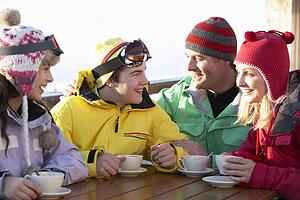 Teenage Family Enjoying Hot Drink In CafÃ© At Ski Resort