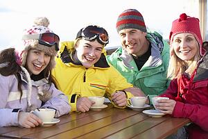 Teenage Family Enjoying Hot Drink In CafÃ© At Ski Resort