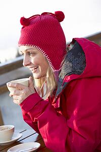 Woman Enjoying Hot Drink In CafÃ© At Ski Resort