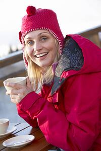 Woman Enjoying Hot Drink In CafÃ© At Ski Resort