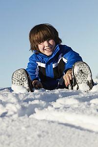 Young Boy Playing In Snow On Holiday In Mountains